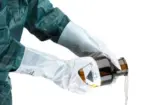 Weißer Ansell AlphaTec 02-100 Chemikalienschutzhandschuh beim Ausgießen von Chemikalien aus einer Flasche