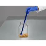 Anwendung des detektierbaren, blauen Bürkle SteriPlast Probenlöffels mit langem Griff bei der Probenahme von Mais aus einem Behälter.