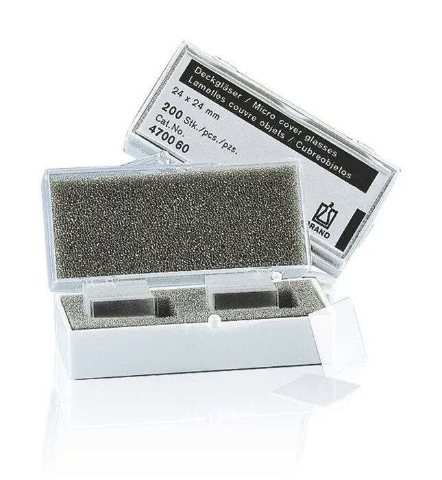 Brand Deckgläser 24x24 mm Dicke Nr. 1 reinweiß Offene Verpackung und einzelne Brand Deckgläser (24x24 mm, Dicke Nr. 1, reinweißes Borosilikatglas) für die Mikroskopie im Labor.